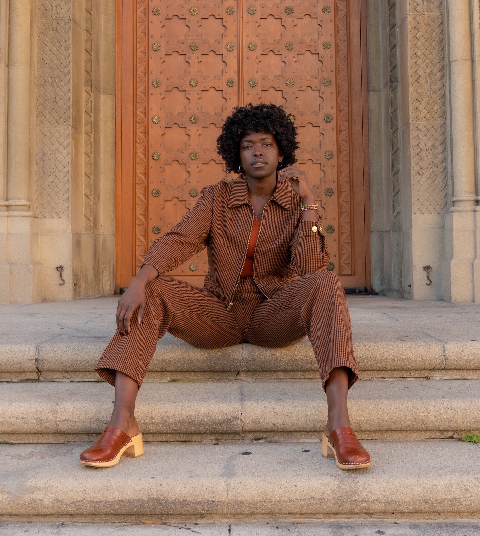 Reece wearing Ricky Jacket in Brown Checker, Checker Trousers in Brown, and Tank Top in Burnt Orange