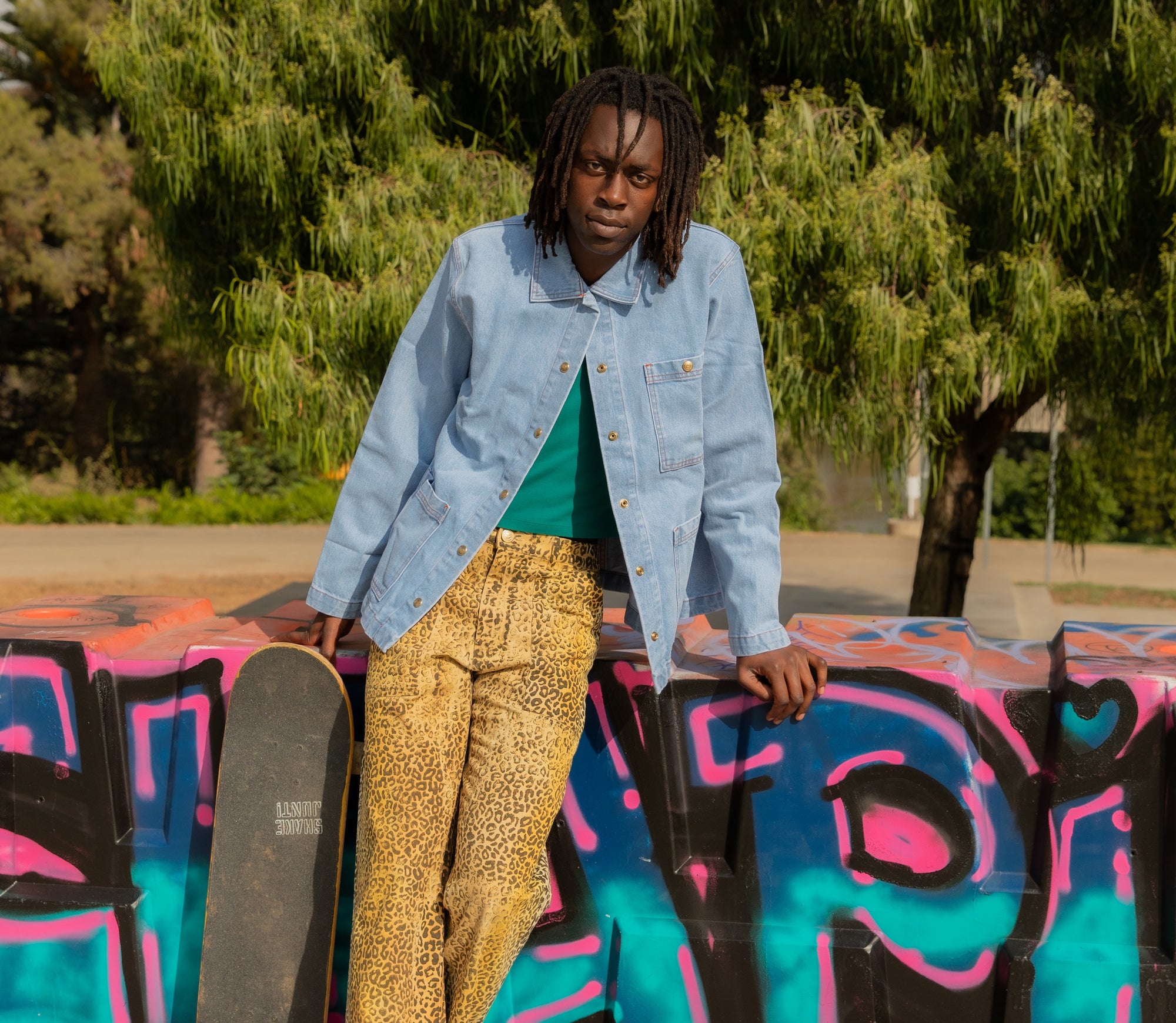 Malcom is wearing Leopard Work Pants, Indigo Denim Work Jacket in Light Wash, and Cropped Tank Top in Hunter Green