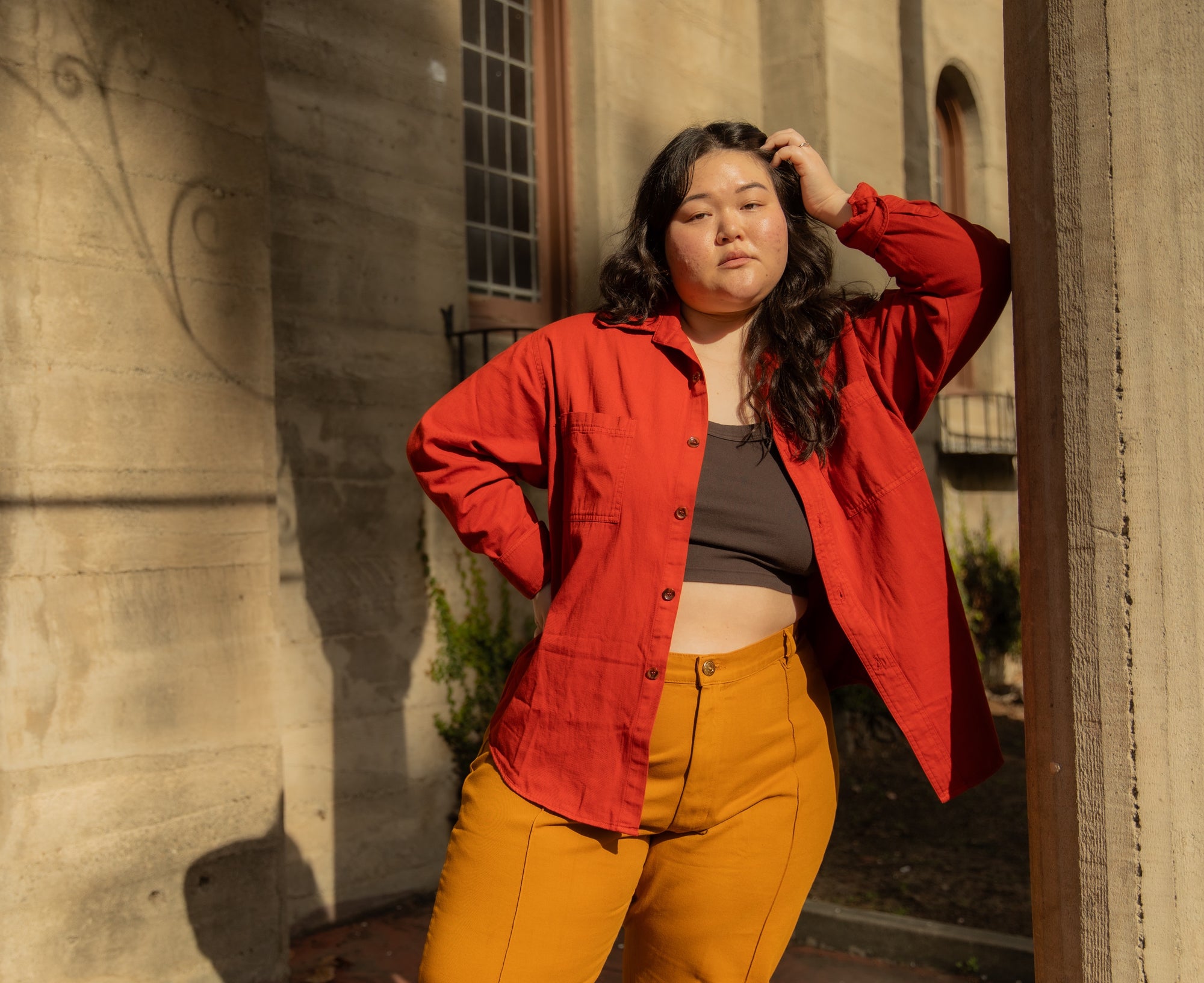 Ashley is wearing Oversize Overshirt in Paprika, Cropped Tank Top in Espresso Brown and Western Pants in Spicy Mustard