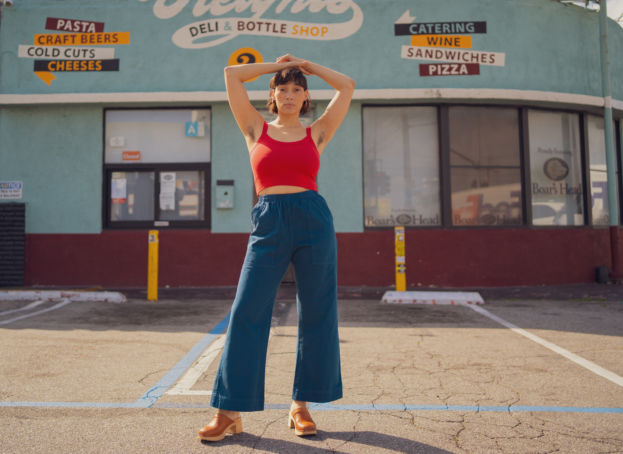 Tiara is wearing Action Pants in Lagoon and Cami in Mustang Red