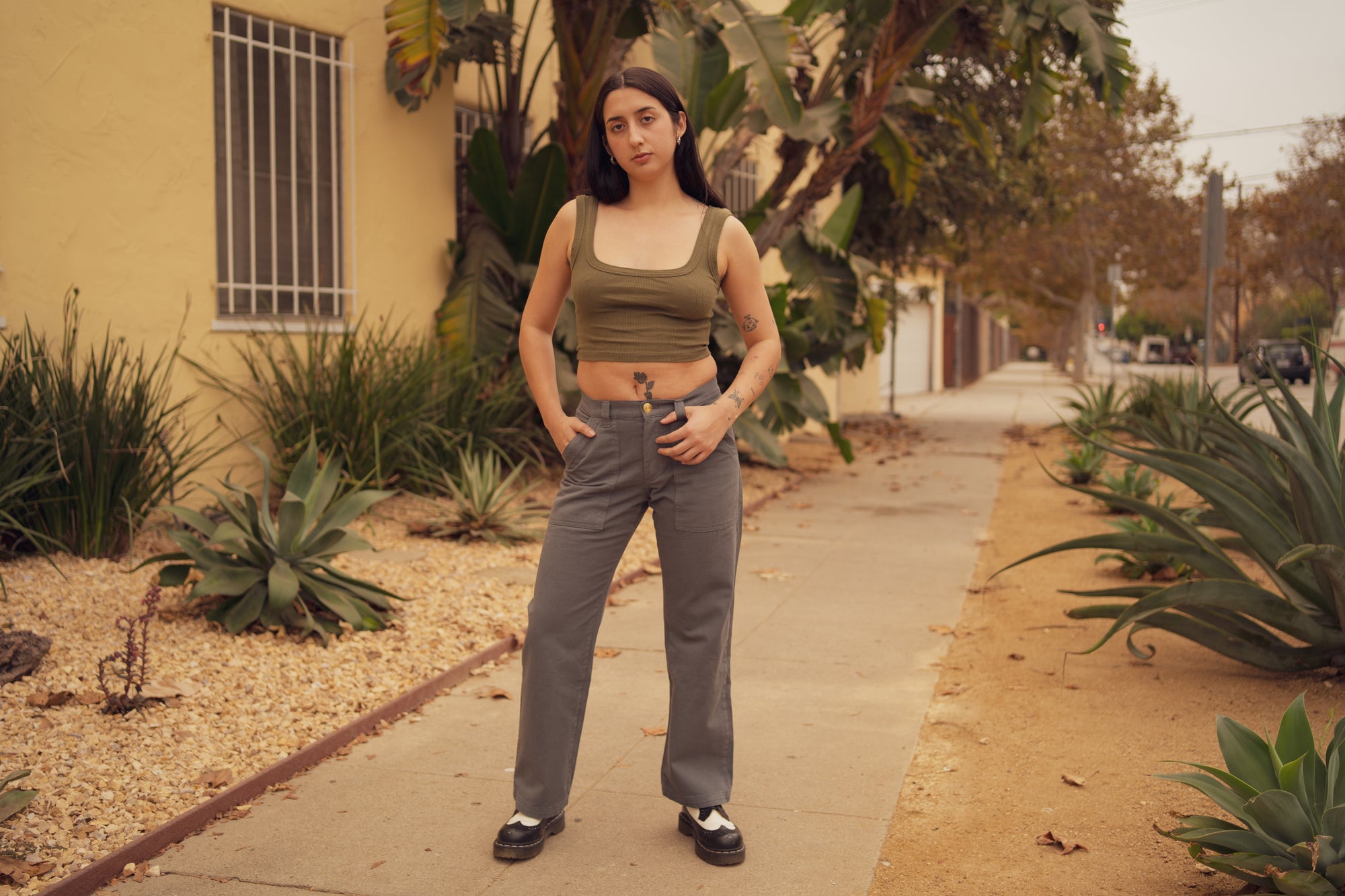 Betty is wearing Mid Rise Work Pants in Slate Grey and Square Neck Tank in Surplus Green