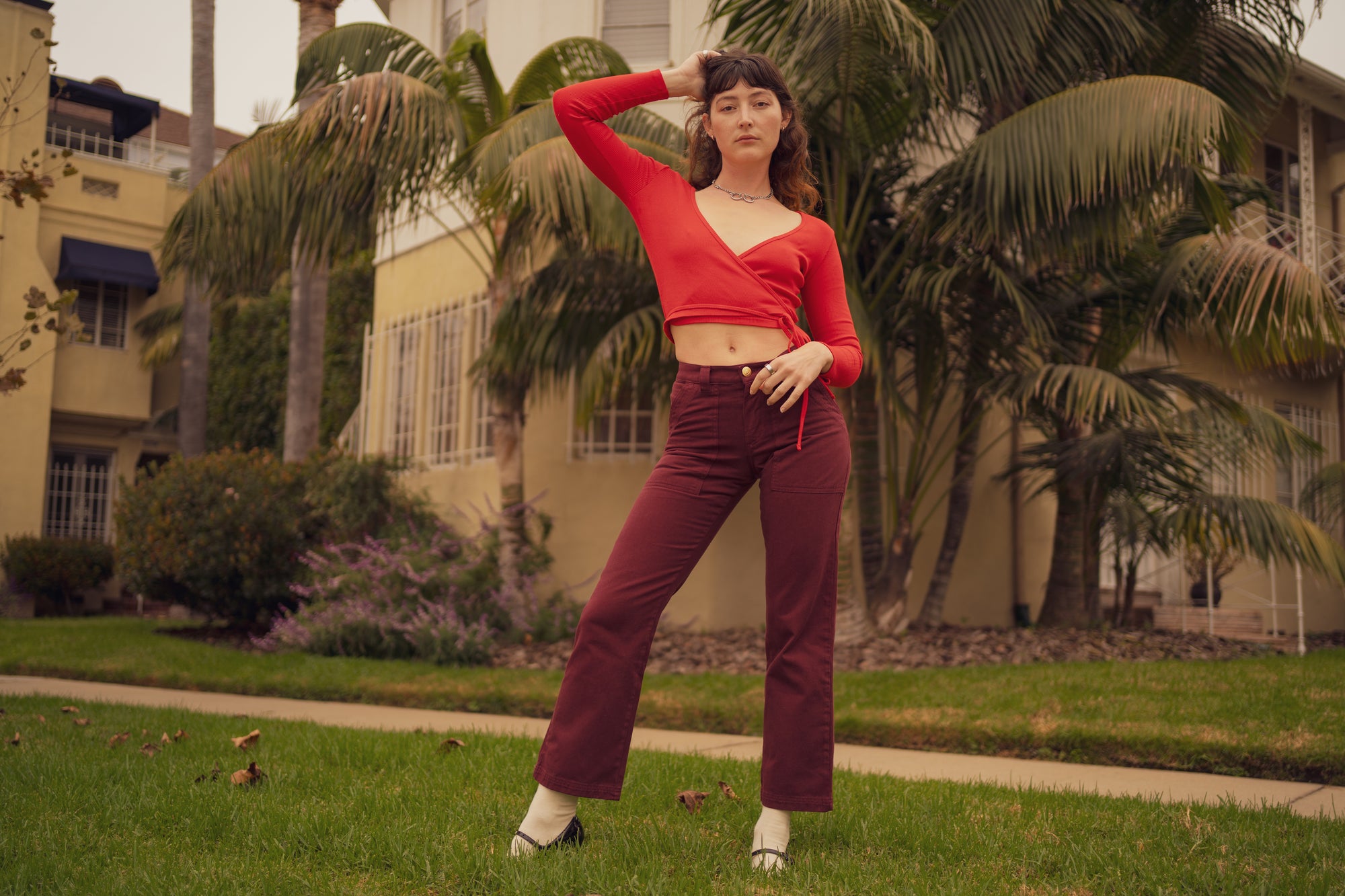 Alexandra Skye is wearing Wrap Top in Mustang Red and Mid-Rise Work Pants in Red Wine