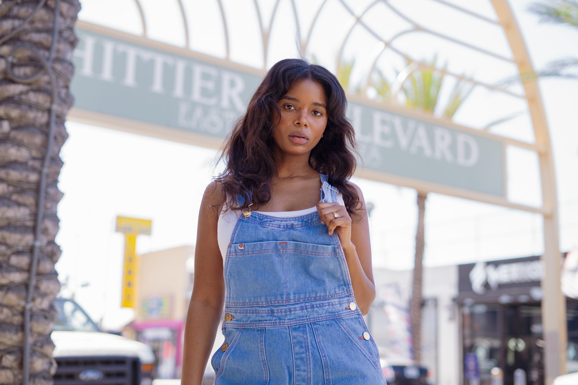 Kandia is wearing Indigo Denim Overalls in Light Wash and Cropped Tank in Vintage Tee Off-White