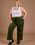 Juliet is 5'8" and wearing 1XL Organic Action Pants in Evergreen paired with vintage tee white Cropped Tank Top