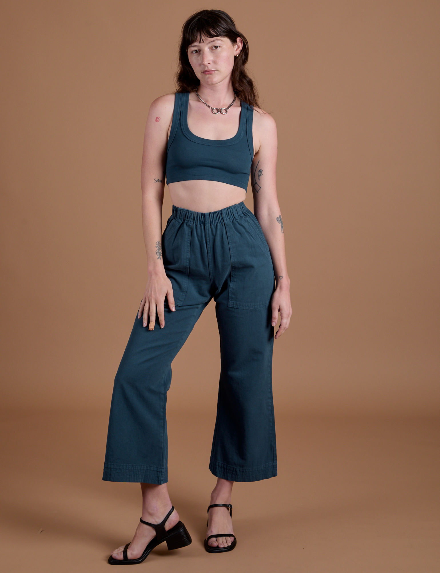 Alex is 5’8” and wearing XXS Action Pants in Lagoon paired with lagoon Mini Tank