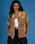 Kandia is 5'3" and wearing XXS Tiger Pantry Button Up
