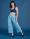 Alex is 5’8” and wearing XXS Painted Drop Pocket Cargo Pants in Baby Blue paired with lagoon Mini Tank