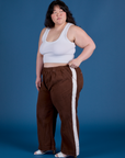 Ashley is 5’7” and wearing 1XL Painted Action Pants in Fudgesicle Brown paired with vintage tee white Cropped Tank