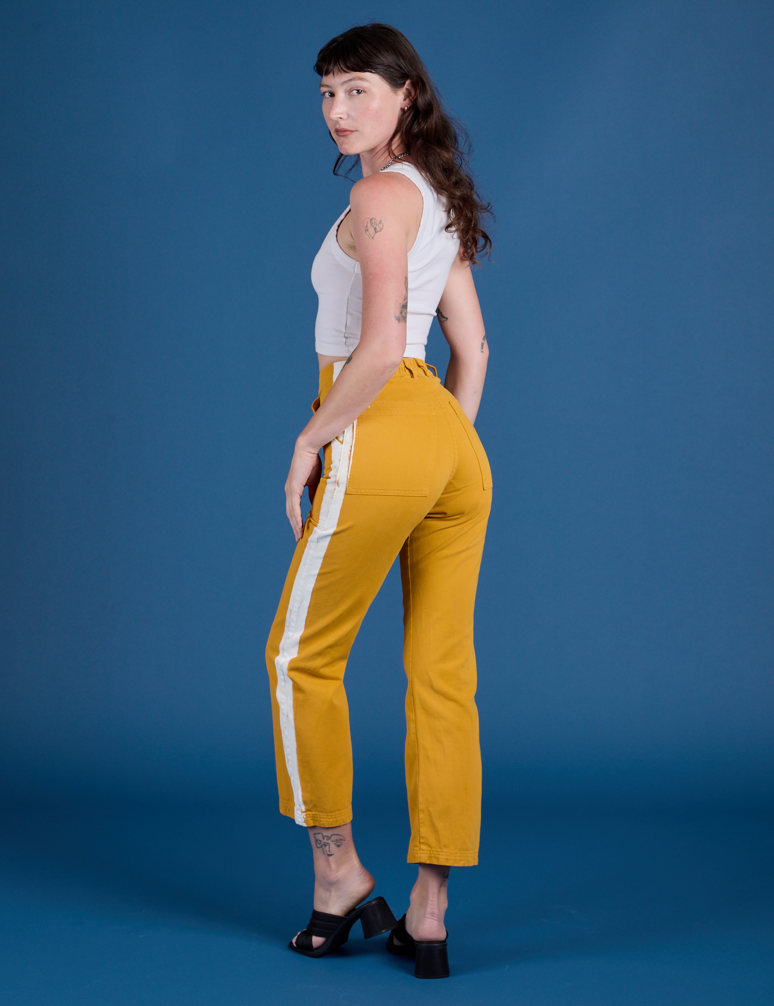 Angled back view of  Painted Work Pants in Mustard Yellow on Alex