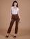 Alex is 5’8” and wearing XXS Carpenter Jeans in Fudgesicle Brown paired with a Cropped Tank in Vintage Tee White