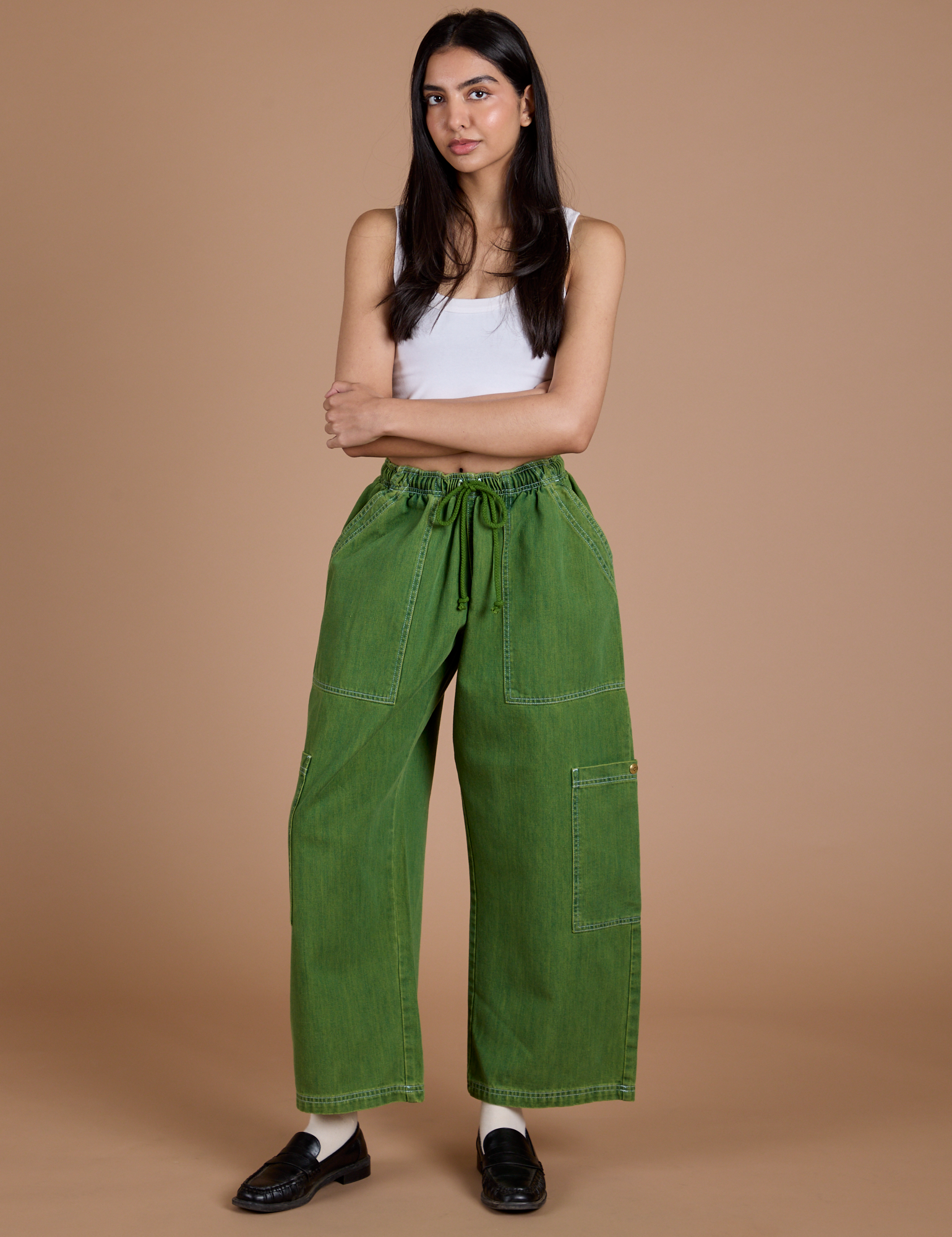 Anjaline 5'7" is and wearing XXS Denim Drop Pocket Pants in Green Overdye paired with vintage tee white Cropped Tank