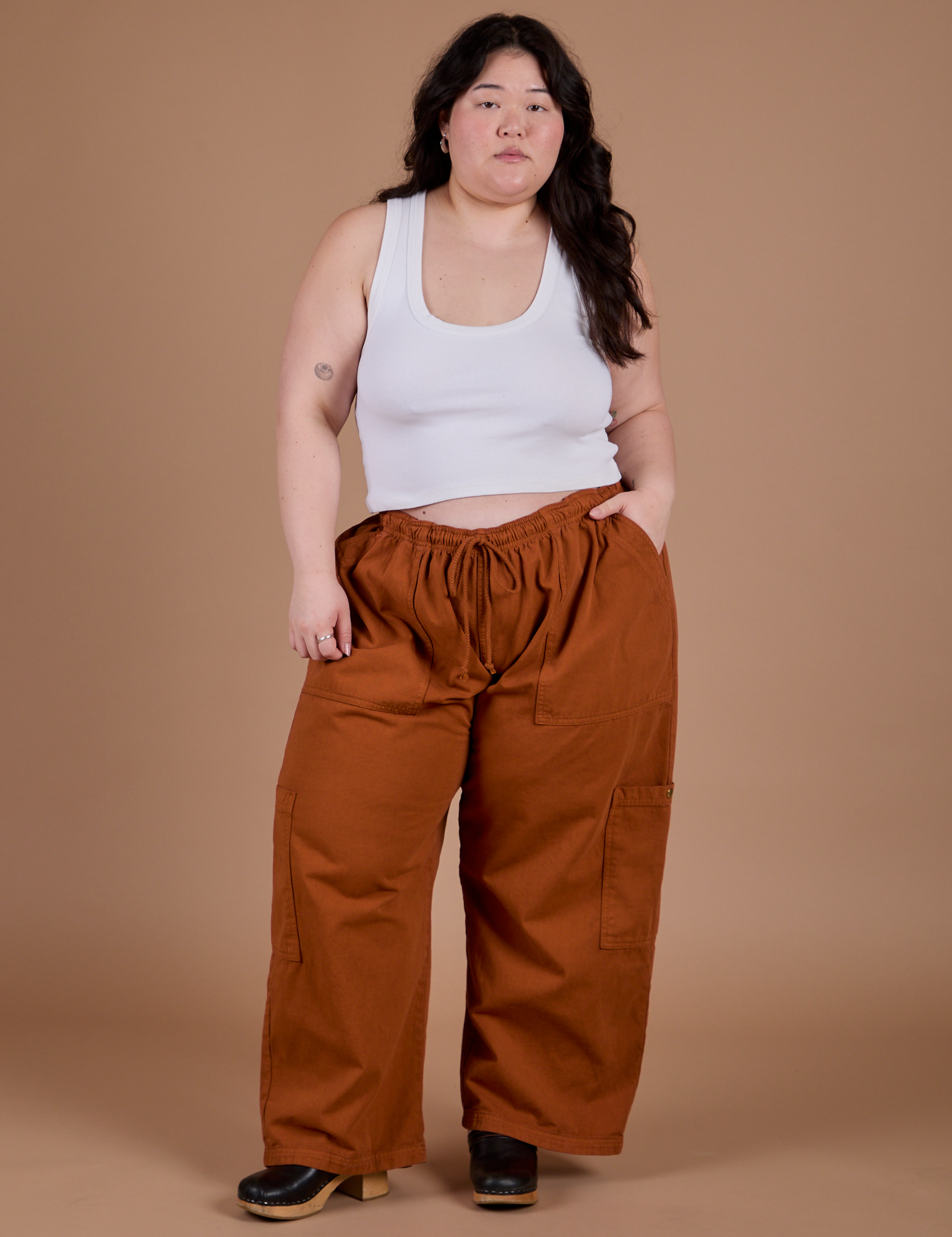 Ashley is 5'7" and wearing 1XL Drop Pocket Cargo Pants in Burnt Terracotta
