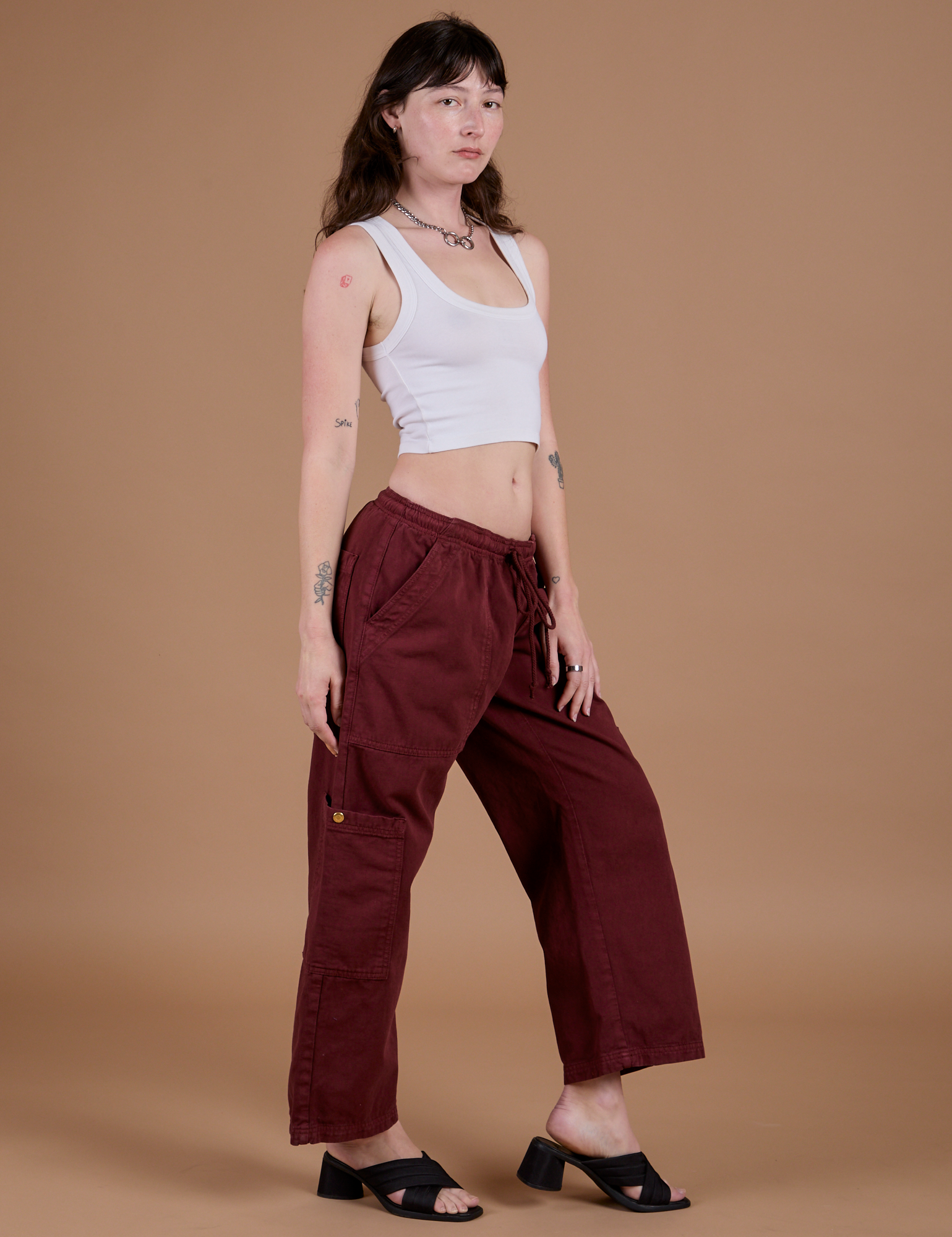 Alex is 5’8” and wearing XXS Drop Pocket Cargo Pants in Red Wine paired with vintage tee white Cropped Tank
