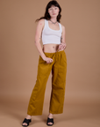 Alex is 5’8” and wearing XXS Drop Pocket Cargo Pants in Spicy Mustard  paired with vintage tee white Cropped Tank