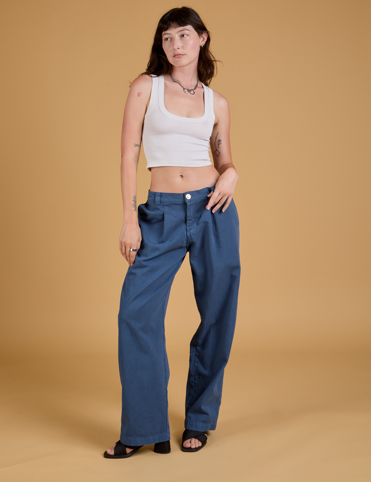 Alex is 5'8" and wearing XXS Baggy Mid-Rise Trousers in French Blue paired with a vintage tee white Cropped Tank