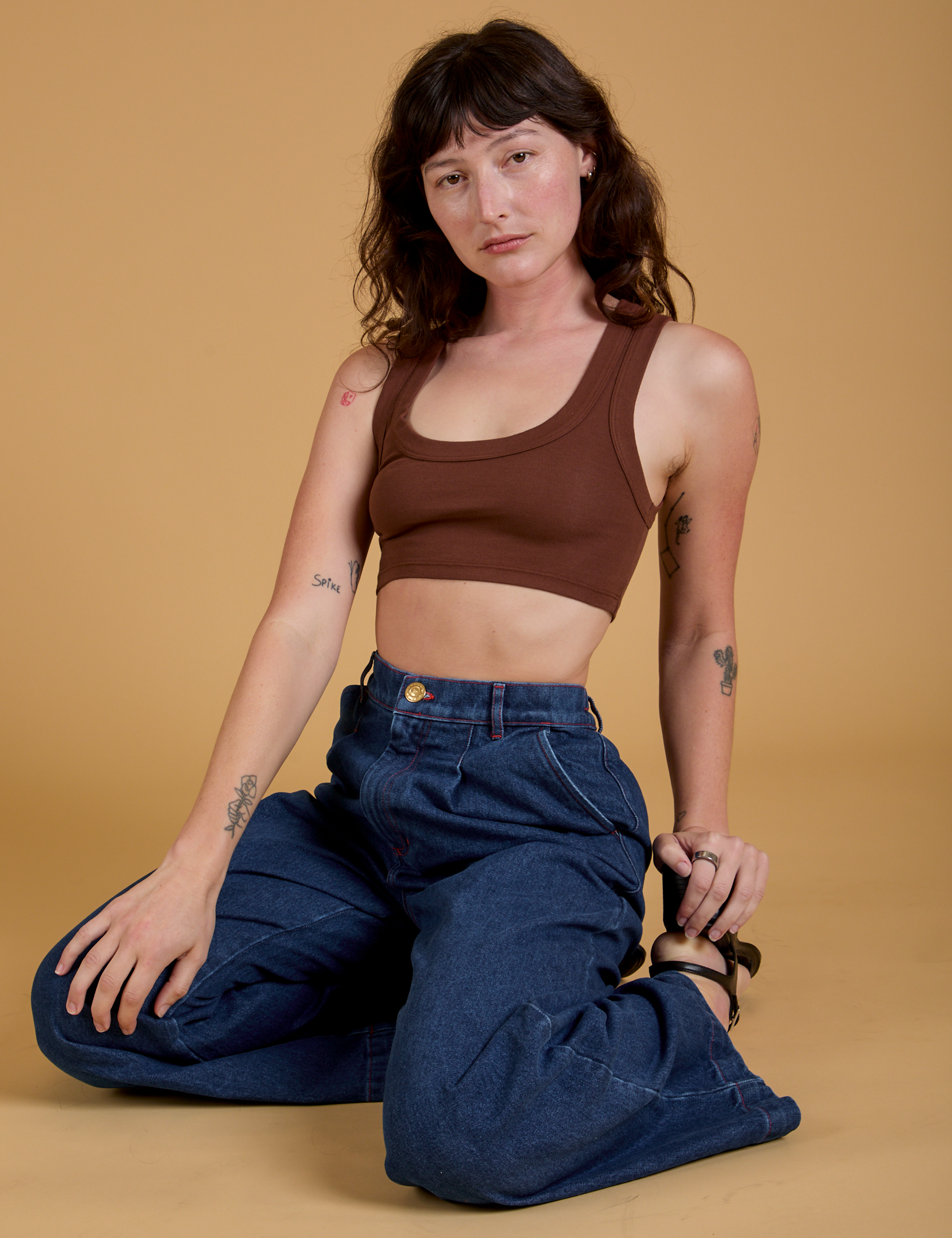 Alex is wearing Mini Tank in Fudgesicle Brown and dark wash Indigo Wide Leg Trousers