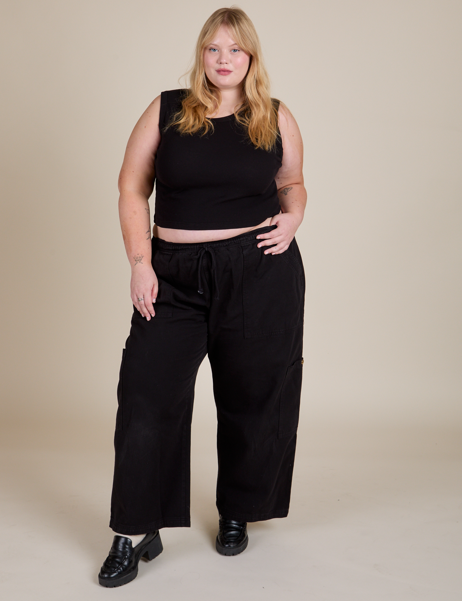 Juliet is 5'7" and wearing L Muscle Tee in Basic Black paired with black Drop Pocket Cargo Pants