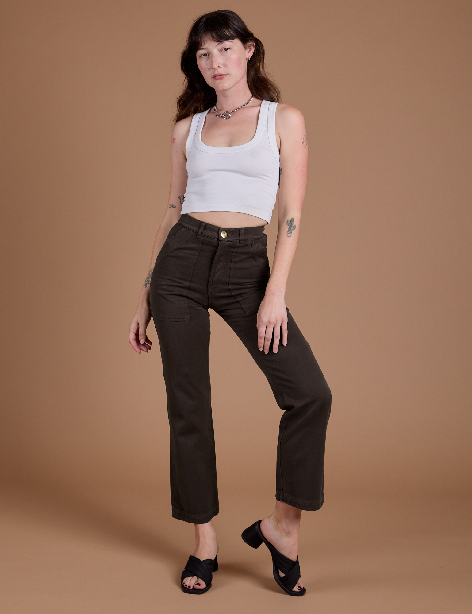 Alex is 5'8" and wearing XXS Organic Work Pants in Espresso Brown paired with vintage tee white Cropped Tank