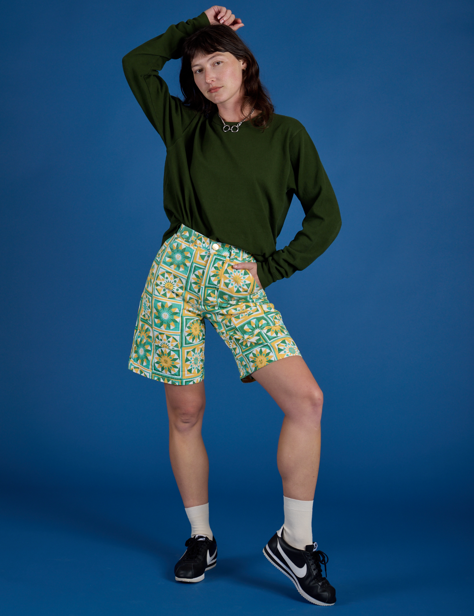 Alex is 5’8” and wearing XXS Longline Work Shorts in Spring Quilt Print paired with evergreen Long Sleeve Burly Tee