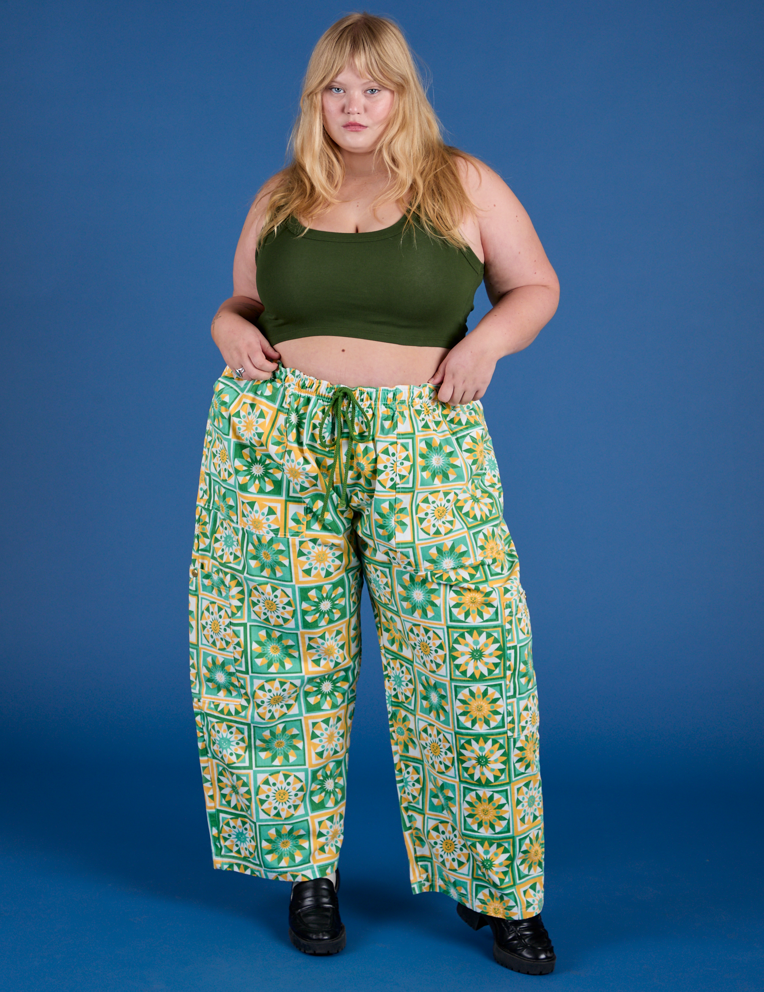Juliet is 5’7” and wearing 2XL Drop Pocket Cargo Pants in Spring Quilt Print paired with evergreen Mini Tank