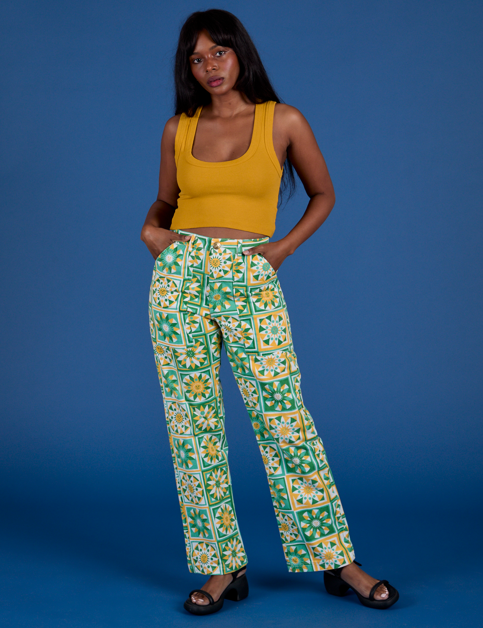 Kandia is 5’3” and wearing XS Work Pants in Spring Quilt Print paired with a mustard yellow Cropped Tank