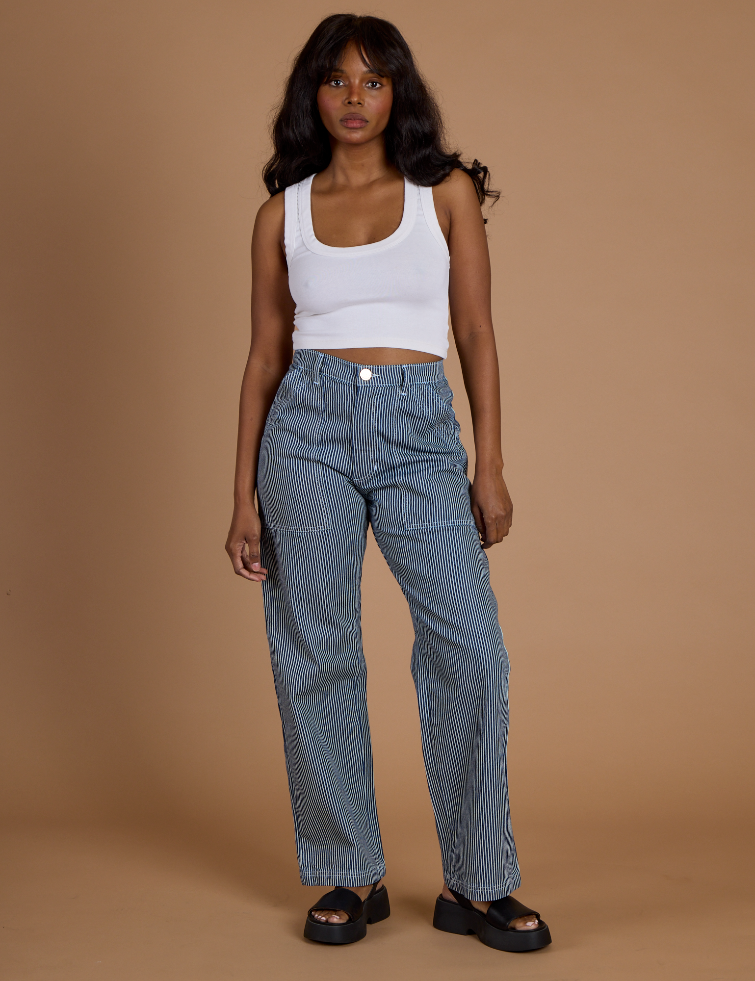 Kandia is 5’3” and wearing XS Railroad Denim Work Pants in Natural paired with vintage tee white Cropped Tank Top