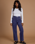 Kandia is 5’3” and wearing XS Railroad Denim Work Pants in Faded Grape Overdye paired with vintage tee white Long Sleeve Baby Tee