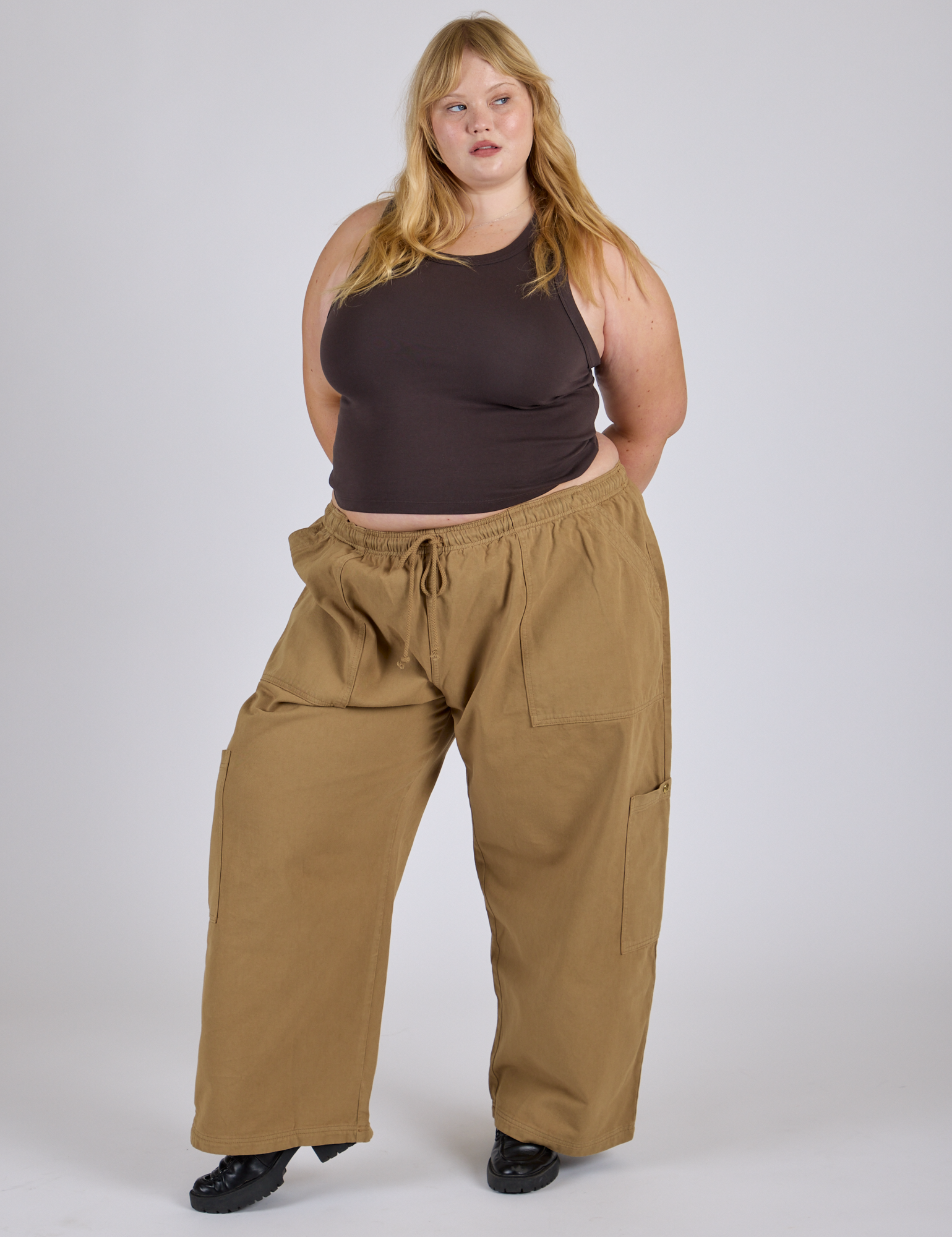 Juliet is 5’7” and wearing 2XL Drop Pocket Cargo Pants in Desert Brown paired with espresso brown Racerback Tank
