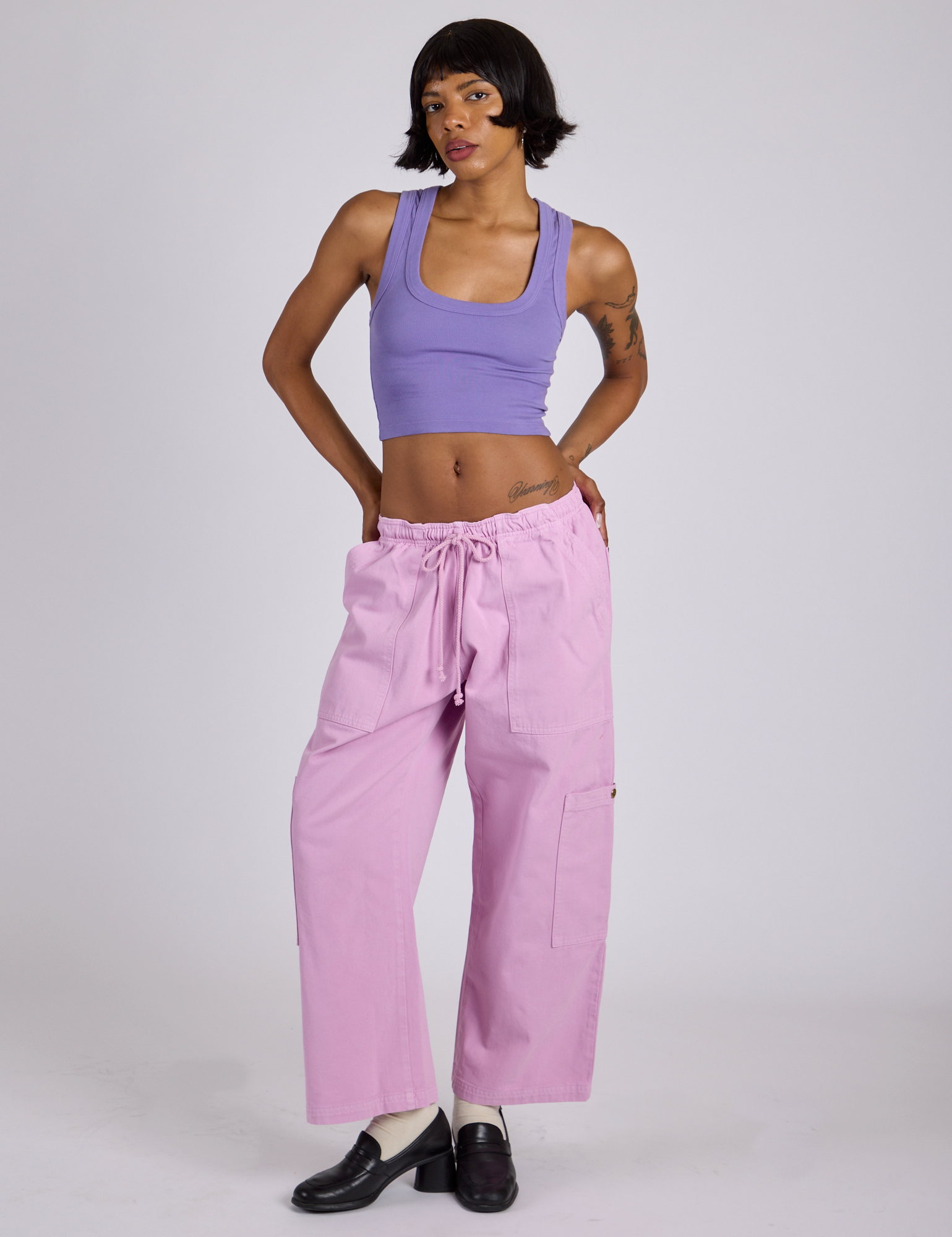 Kira is 5’10” and wearing XS Drop Pocket Cargo Pants in Lilac Purple paired with faded grape Cropped Tank