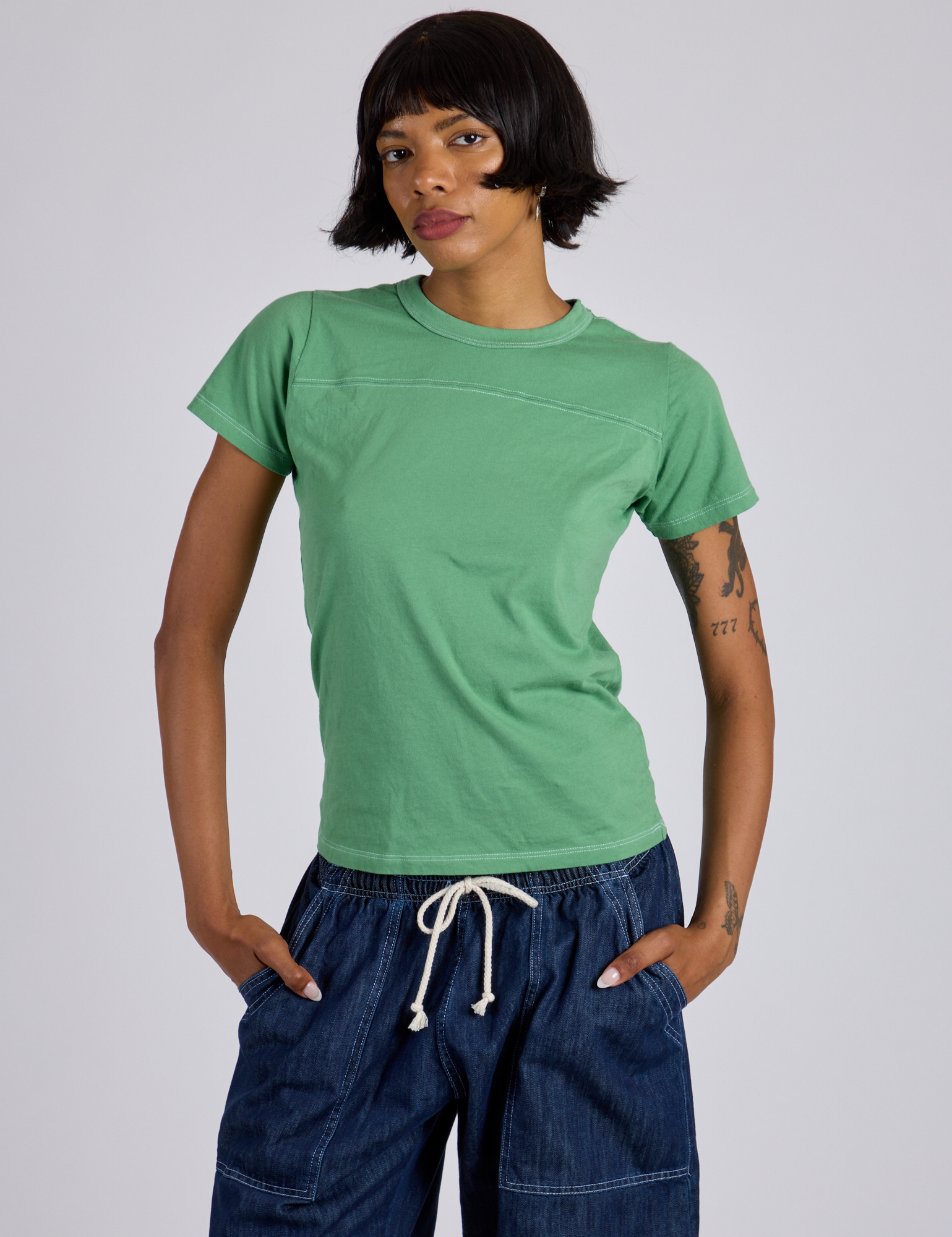 Kira is 5’10” and wearing P Jr. Varsity Tee in Seafoam Green
