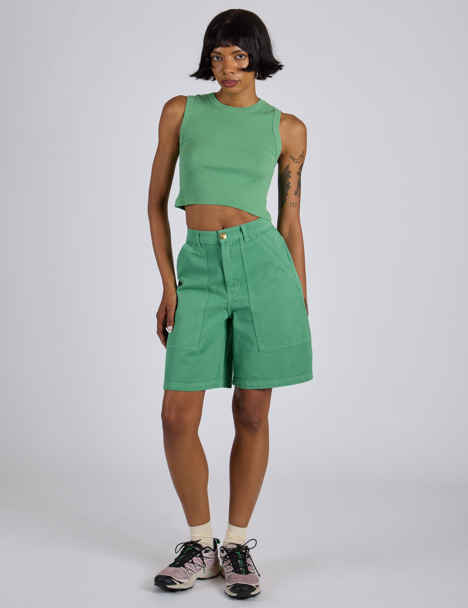 Kira is 5’10” and wearing XS Longline Work Shorts in Seafoam Green paired with matching Muscle Tee