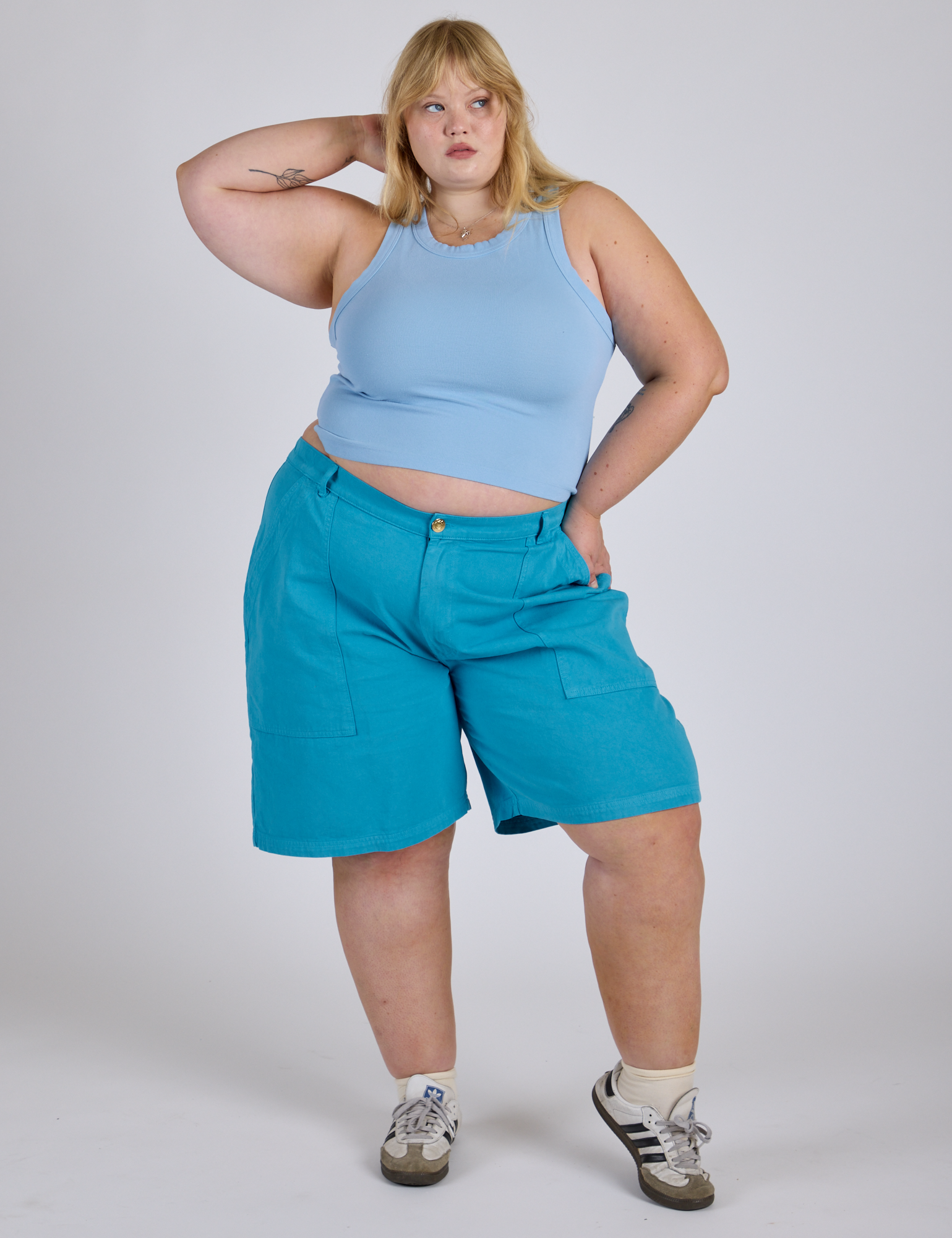 Juliet is 5’7” and wearing 2XL Longline Work Shorts in Hawaiian Blue paired with a baby blue Racerback Tank