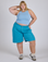 Juliet is 5’7” and wearing 2XL Longline Work Shorts in Hawaiian Blue paired with a baby blue Racerback Tank