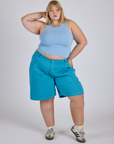 Juliet is 5’7” and wearing 2XL Longline Work Shorts in Hawaiian Blue paired with a baby blue Racerback Tank