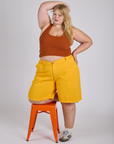 Juliet is 5’7” and wearing 2XL Longline Work Shorts in Sunshine Yellow paired with burnt terracotta Cropped Tank