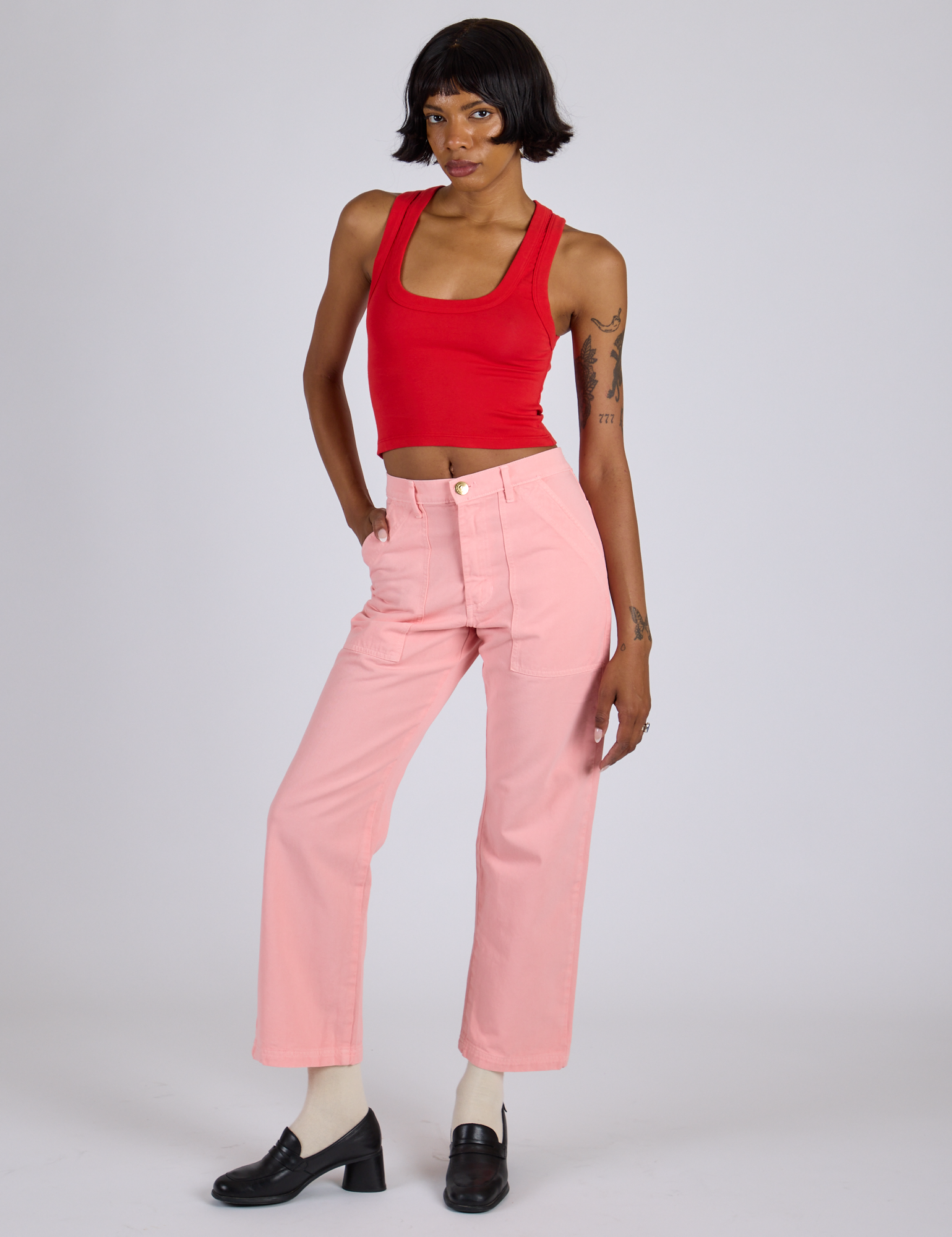 Kira is 5’10” and wearing XS Work Pants in Baby Pink paired with mustang red Cropped Tank