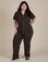 Ashley is 5'7" and wearing 1XL Short Sleeve Jumpsuit in Espresso Brown