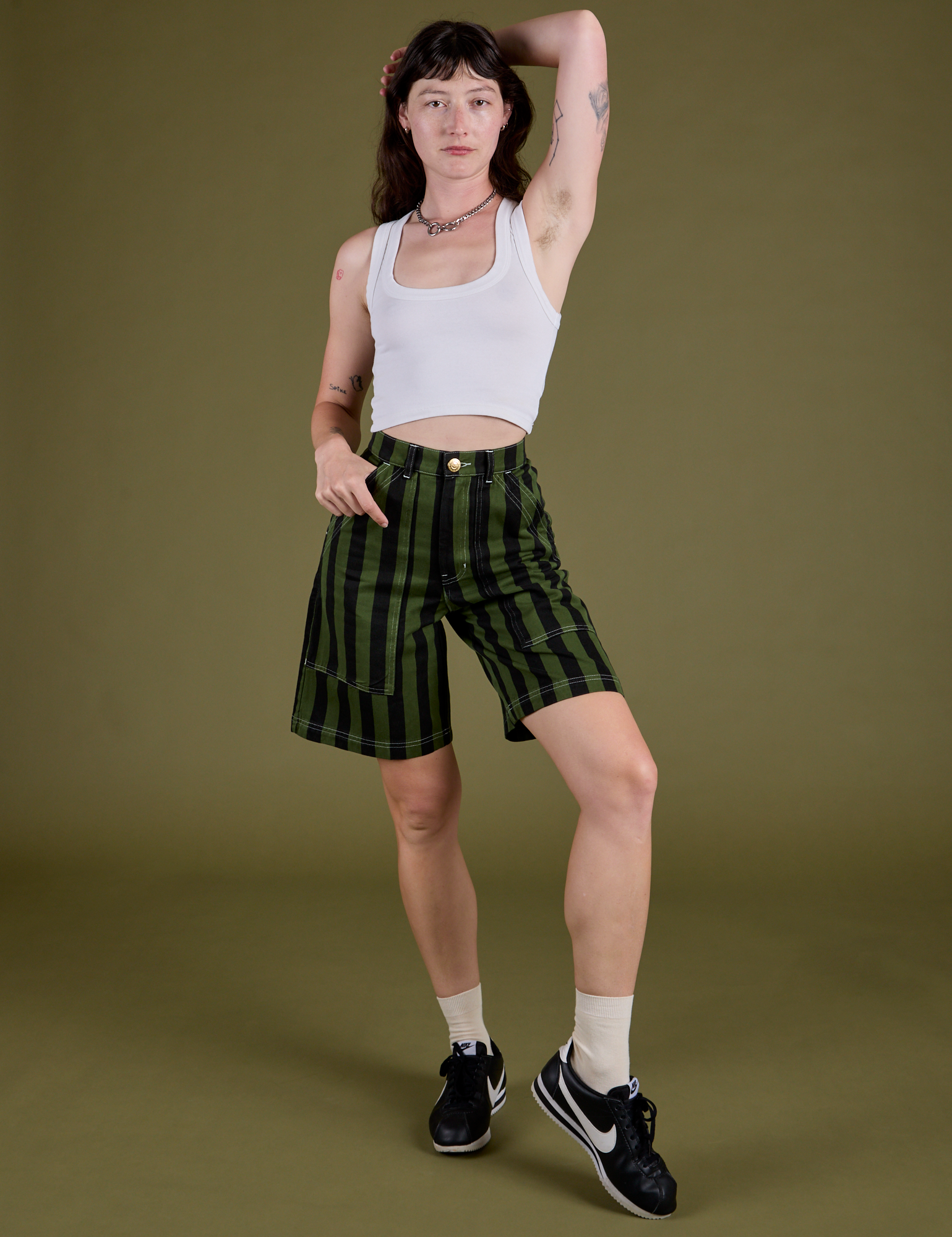 Alex is 5’8” and wearing XXS Longline Work Shorts in Evergreen paired with vintage tee white Cropped Tank