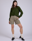 Alex is 5’8” and wearing XXS Pleated Trouser Shorts in Khaki Grey paired with evergreen Long Sleeve Burly Tee