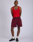 Jerrod is 6’3” and wearing M Pleated Trouser Shorts in Red Wine paired with mustang red Cropped Tank