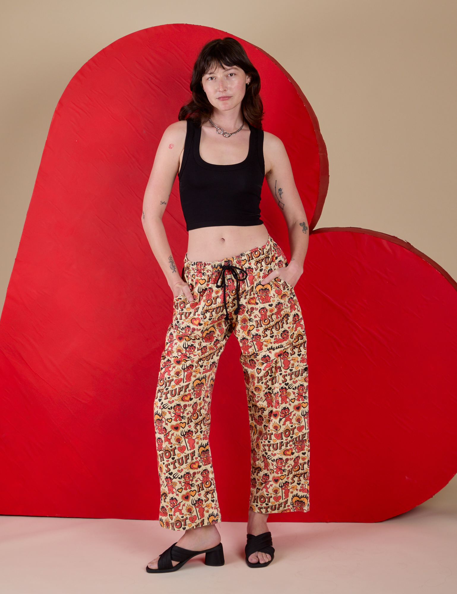 Alex is 5’8” and wearing XXS Hot Stuff Drop Pocket Cargo Pants paired with a black Cropped Tank