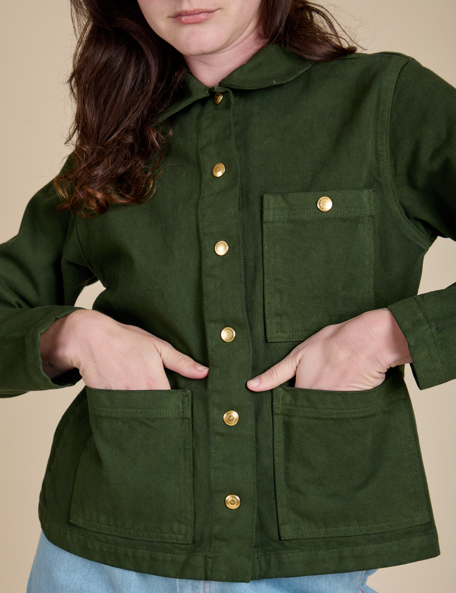 Alex has both hands in the front pockets of Denim Work Jacket in Evergreen