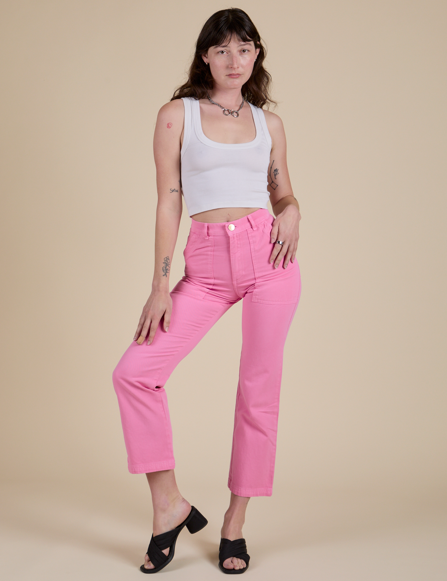 Alex is 5’8” and wearing XS Work Pants in Bubblegum Pink paired with a vintage tee white Cropped Tank