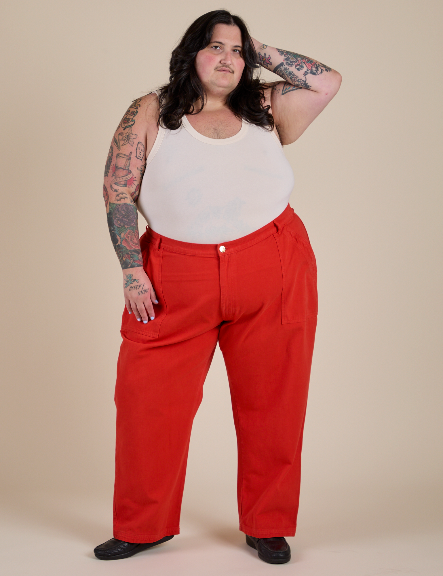 Sam is 5’10” and wearing 4XL Work Pants in Mustang Red paired with Cropped Tank in Vintage Tee White