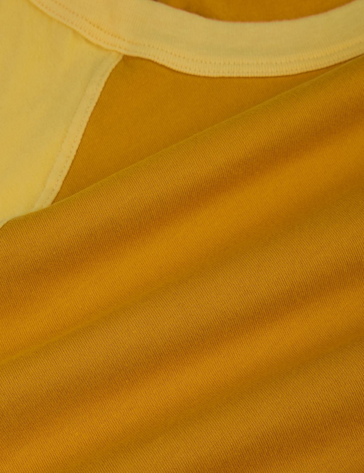 Fabric close up of the Mustard Yellow/Butter Raglan Tee