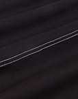 Carpenter Jeans in Black fabric detail close up. White stitching on pants.