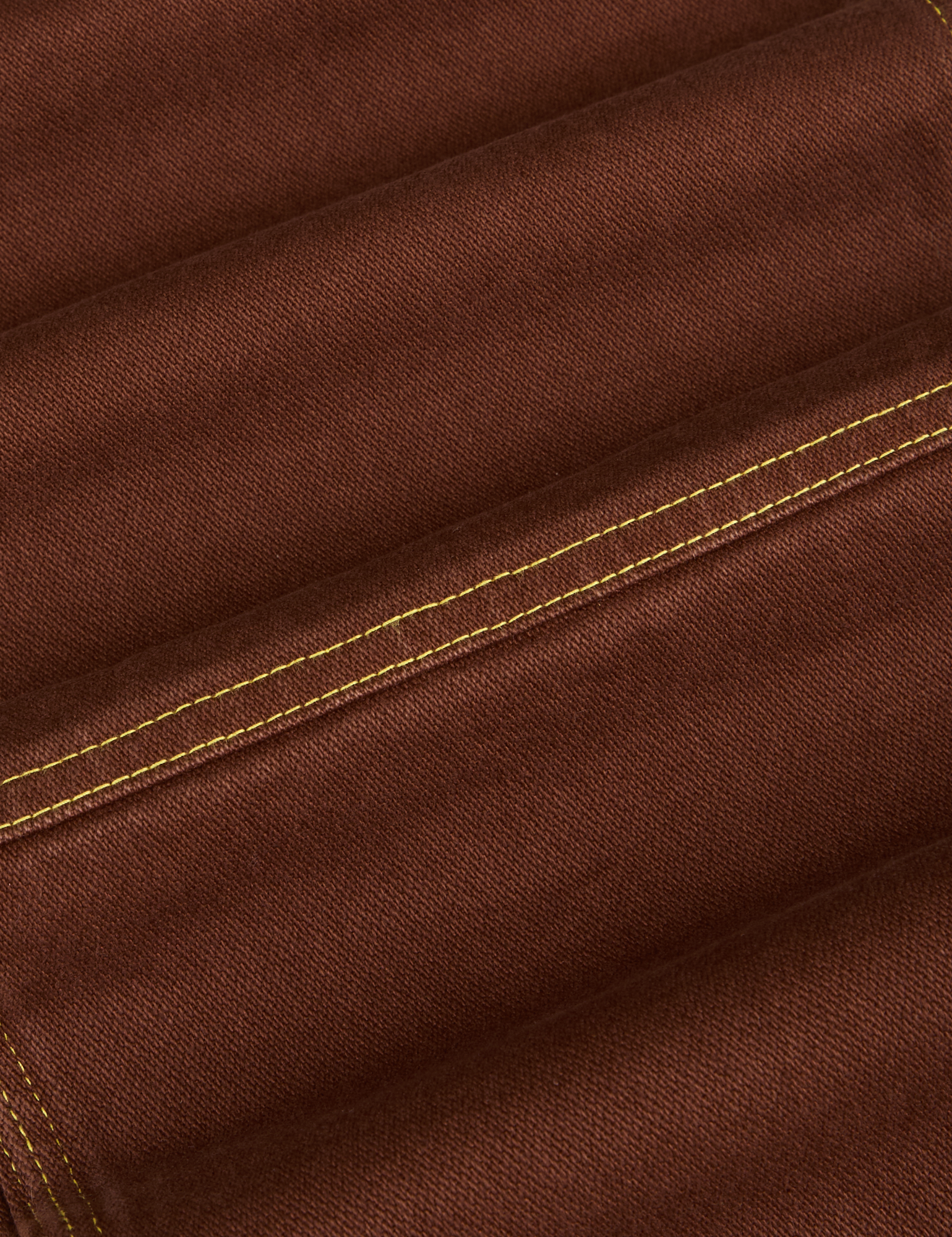 Carpenter Jeans in Fudgesicle Brown fabric detail close up with yellow contrast stitching