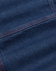 Carpenter Overalls in Dark Wash fabric detail close up. Contrast red top stitching