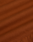 Pleated Trouser Shorts in Burnt Terracotta fabric detail close up