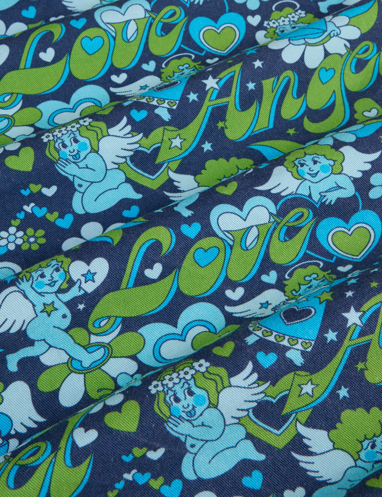 ngel Print Jumpsuit fabric detail close up. Blue and green angles with text Love